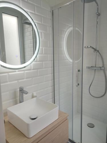 une salle de bain blanche avec un lavabo et une douche dans l'établissement Stylish Parisian Flat near Eiffel Tower, à Paris