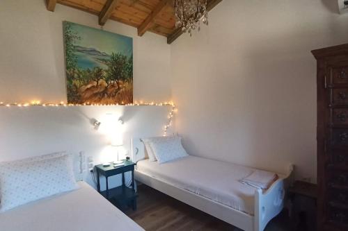 1 dormitorio con 2 camas y un cuadro en la pared en Rizaki Cottage in Nafpaktos, en Nafpaktos