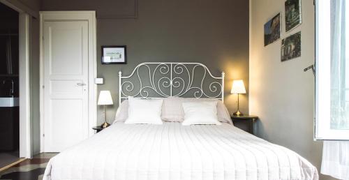 a bedroom with a white bed with white pillows at B&B Villa le Ortensie in Faggeto Lario 