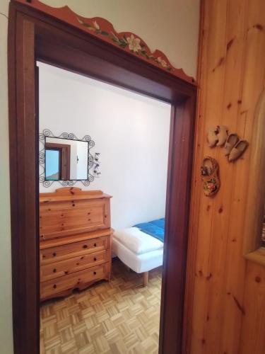 a bedroom with a mirror and a dresser with a bed at Appartamento Centrale in Sappada