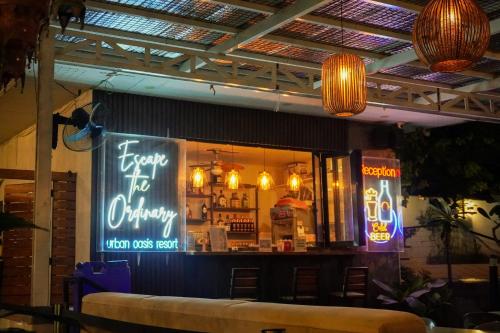 a bar in a restaurant with neon signs in the window at Urban Oasis Resort, Tarlac in Tarlac