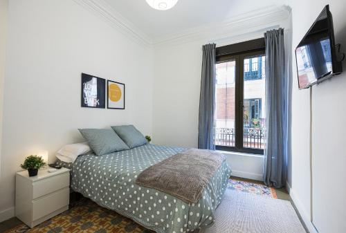 Schlafzimmer mit einem Bett und einem Fenster in der Unterkunft Antón Rooms in Madrid