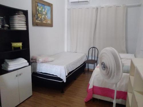 アララングアにあるStudio confortavel - ate 4 pessoasのベッドルーム1室(ベッド2台、ファン付)