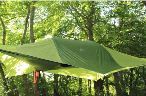 un aeroplano verde è appeso tra gli alberi di 6 personers hytte på Tarm camping a Tarm