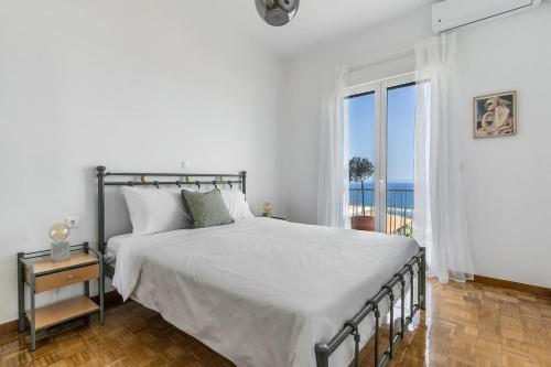 a bedroom with a bed with a view of the ocean at On The Port in Rafina