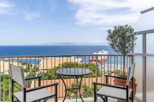 a balcony with a table and chairs and the ocean at On The Port in Rafina