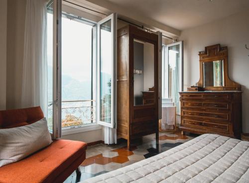 1 dormitorio con 1 cama, vestidor y ventana en B&B Villa le Ortensie en Faggeto Lario 