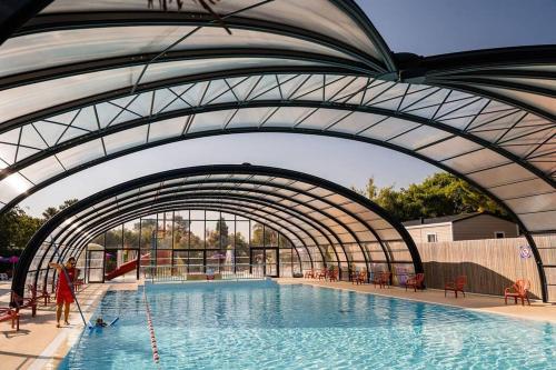 une piscine avec une arche au-dessus de celle-ci dans l'établissement Mer et Soleil 5 étoiles à Oléron emplacement 469 2CH 1SDB 6 personnes, à Les Sables Vignier