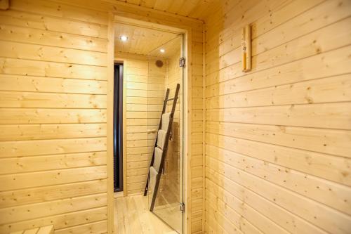 a sauna with a glass door in a wooden wall at Glamping Idyllaglamp Loft in Dzbądzek