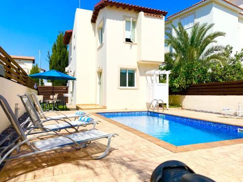 a villa with a swimming pool in front of a house at Villa millie Cyprus in Protaras