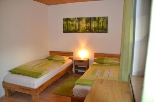 um quarto com 2 camas e uma mesa com um candeeiro em Ferienwohnung Vera em Georgensgmünd