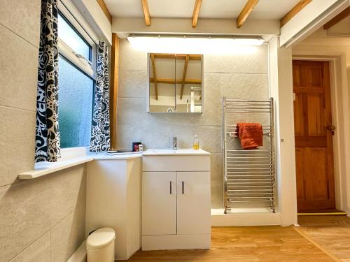 uma casa de banho com um lavatório e um espelho em Cosy Cottage near Canterbury - Perfect for Couples - Dogs Welcome! em Canterbury