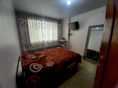 1 dormitorio con 1 cama con manta roja en Espacio para ti y tu familia, en Lima