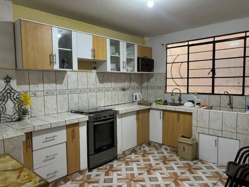 una cocina con armarios de madera y horno negro en Espacio para ti y tu familia, en Lima