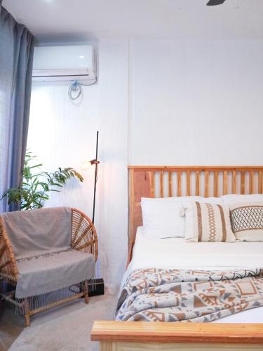 a bedroom with a bed and a chair and a window at Urban Oasis Resort, Tarlac in Tarlac