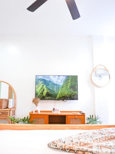 a living room with a tv on top of a dresser at Urban Oasis Resort, Tarlac in Tarlac