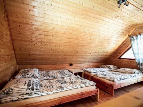 two beds in a log cabin with a window at Storey holiday cottages, Ustronie Morskie in Ustronie Morskie