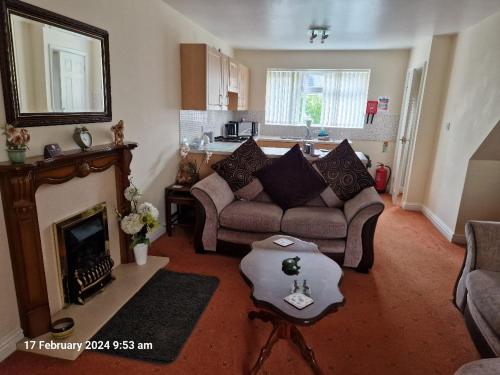 ein Wohnzimmer mit einem Sofa und einem Kamin in der Unterkunft The Annexe in Bridlington