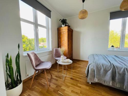 1 dormitorio con 1 cama, 2 sillas y ventanas en Ilmarise Apartment en Viljandi