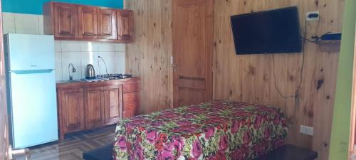 cocina con cama y nevera en una habitación en Los Pioneros, en Puerto Iguazú