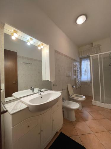 a bathroom with a sink and a toilet and a mirror at Appartamento centro Follonica in Follonica