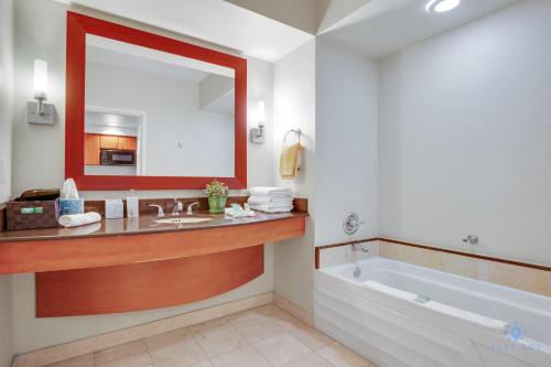 a bathroom with a tub and a sink and a mirror at Luxurious Resort Gym Balcony in Miami Beach