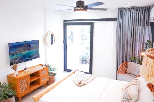 een woonkamer met een bed en een televisie bij Urban Oasis Resort, Tarlac in Tarlac