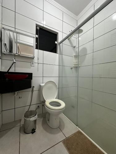 a bathroom with a toilet and a glass shower at Casa de Campo Chácara Divisa Rio Preto e Guapiaçu in Sao Jose do Rio Preto