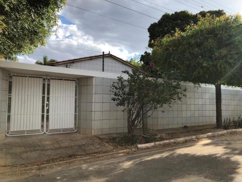 a white building with a large garage at Casa com 4 quartos e área externa com jardim in São Raimundo Nonato