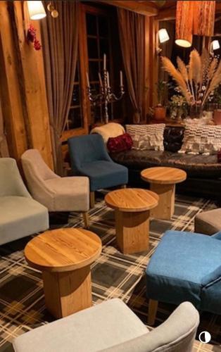 a living room with tables and chairs and a couch at Hôtel des Skieurs in Le Sappey-en-Chartreuse