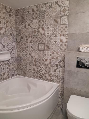 a bathroom with a white tub and a toilet at Villa Simeon in Platis Yialos Sifnos