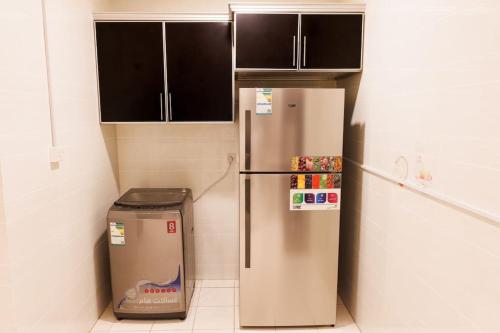 a kitchen with a refrigerator and a trash can at luxury duplex apartment Alkhobar in Al Khobar