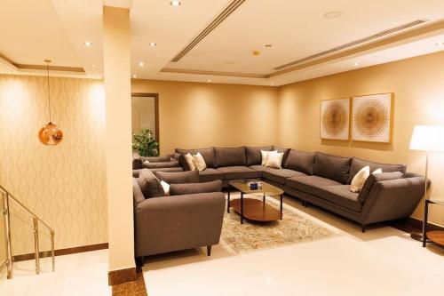uma sala de estar com um sofá e uma mesa em luxury duplex apartment Alkhobar em Al Khobar