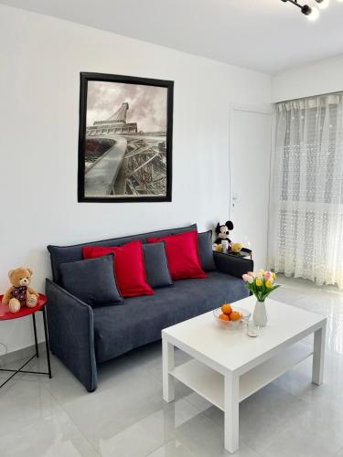 a living room with a blue couch and a white table at Appartement récemment rénové à 1min du métro in Créteil