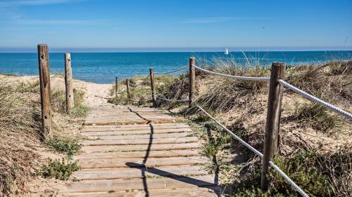 un camino de madera a la playa con el océano en Rincón Marino Alto, en Oliva