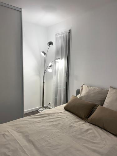 a bedroom with a bed with two lamps and a mirror at Appartement récemment rénové à 1min du métro in Créteil