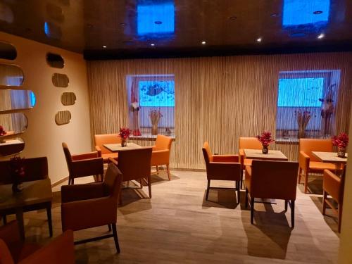 a dining room with tables and chairs and windows at Góry Sowie przystanek DAD HOUSE in Sokolec