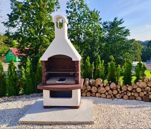 a barbecue cooker sitting on top of a pile of logs at Góry Sowie przystanek DAD HOUSE in Sokolec