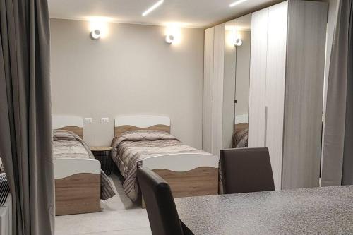sypialnia z 2 łóżkami, stołem i lustrem w obiekcie Villaggio Cavour Emanuele w mieście Settimo Milanese