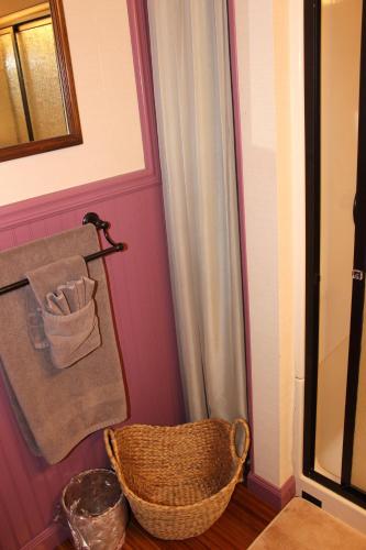 a bathroom with a basket and a pink wall at Carriage Stop Bed & Breakfast in Palmyra