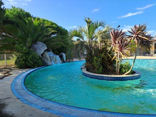 basen z palmami i wodospadem w obiekcie Mobil Home w mieście Plouescat