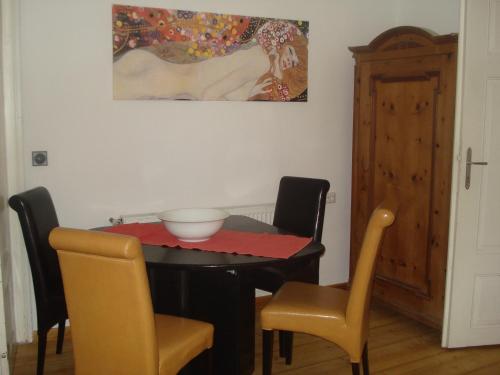 einen Esstisch mit Stühlen und ein Gemälde an der Wand in der Unterkunft Landhaus Ferk in Unterburg am Klopeiner See