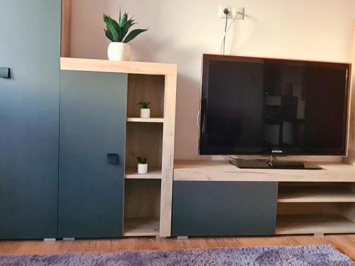 um suporte de televisão com uma televisão de ecrã grande em Cozy Apartment- zona centrala em Bacau