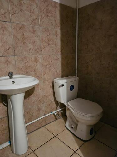 a bathroom with a toilet and a sink at cerca aeropuerto tobias bolaños in San José