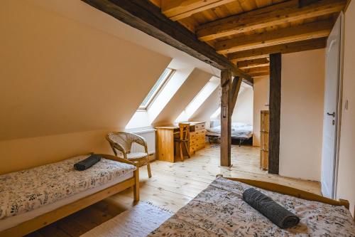- une chambre avec 2 lits dans une pièce dotée de lucarnes dans l'établissement Cottage Prameny, à Prameny