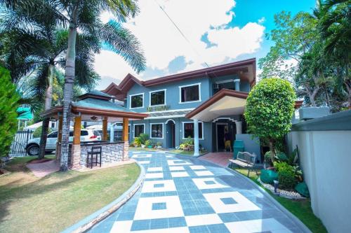 a house with a palm tree and a driveway at The Gabriella Bed and Breakfast in Tagbilaran City