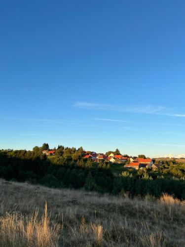 a view of a town from a field with a blue sky at Casa Roma Lac in Brebu Nou