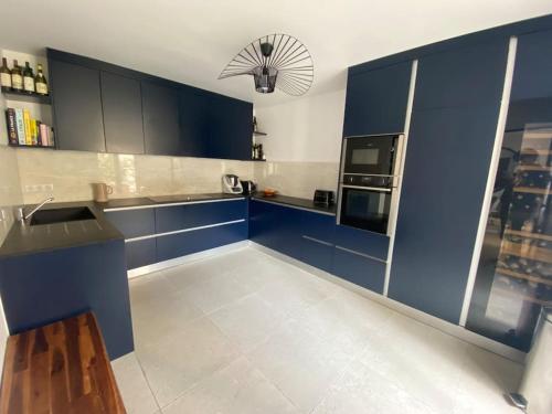 a kitchen with blue cabinets and a white tile floor at Dupleix Boulogne plein centre in Boulogne-Billancourt