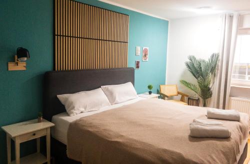 1 dormitorio con 1 cama grande y paredes azules en Gemütliche Stadtwohnung I City Centre en Ulm
