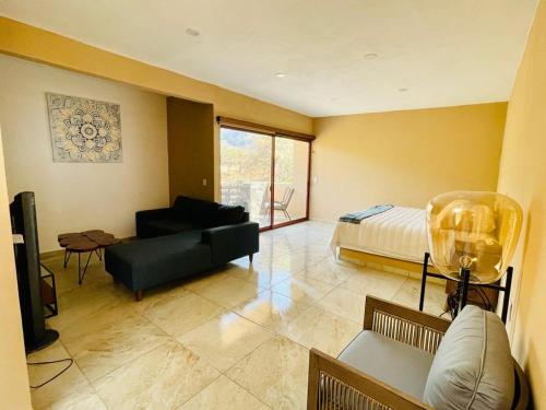 ein Wohnzimmer mit einem Sofa und einem Bett in der Unterkunft Villas Ecuestre Hotel Tepoztlán in Tepoztlán